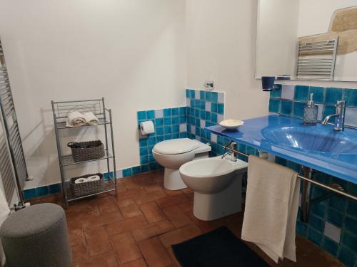 a blue and white bathroom with a toilet and a sink at Almarè Confort Rooms in Terrasini