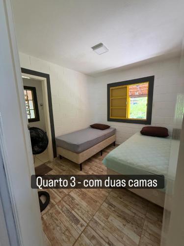 a small room with two beds and a window at Vale Verde in Jacutinga
