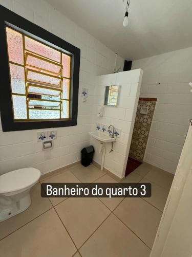 a bathroom with a toilet and a sink and a window at Vale Verde in Jacutinga