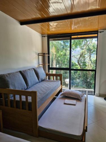 a living room with a couch and a window at Loft da Árvore in Petrópolis