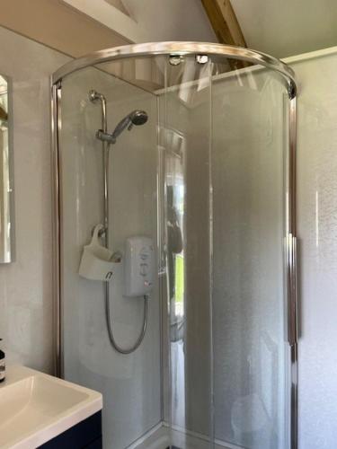 a shower with a glass door in a bathroom at The Garden Rooms in Spittal