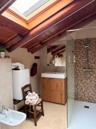 a bathroom with a sink and a shower and a chair at La casa Arancione in Boves