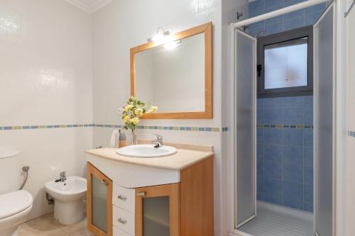 a bathroom with a sink and a toilet and a mirror at Enjoy life in our apartment. Wifi Parking in Guardamar del Segura
