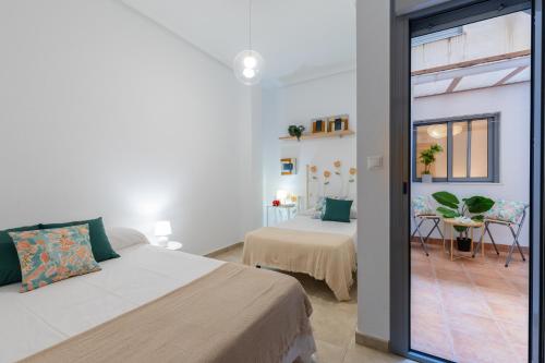 a bedroom with two beds and a sliding glass door at Enjoy life in our apartment. Wifi Parking in Guardamar del Segura