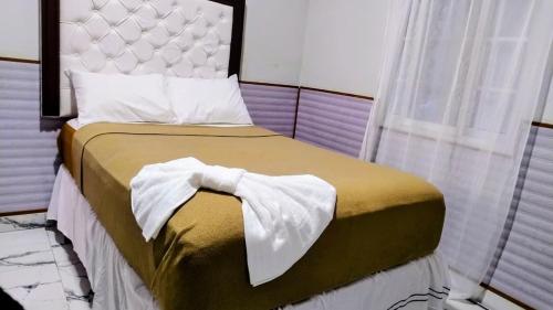 a bedroom with a bed with a white headboard and a window at Hotel Urban Center RM in San Marcos