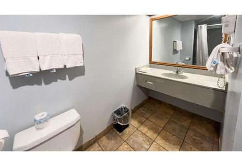 a bathroom with a toilet and a sink and a mirror at Studio 6 Suites - Tiffin, OH in Tiffin