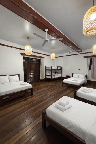 a room with three beds and a ceiling at Casona El Remanso in Mariquita