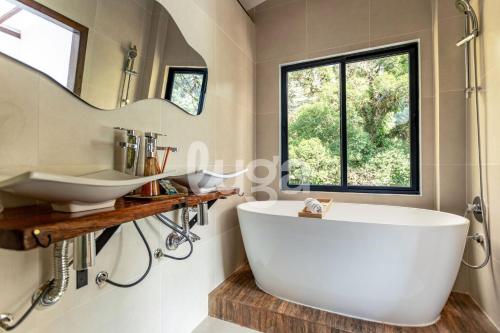 a bathroom with a large tub and a sink at Faxinal das Águas Retreat - 5min from downtown in Rancho Queimado