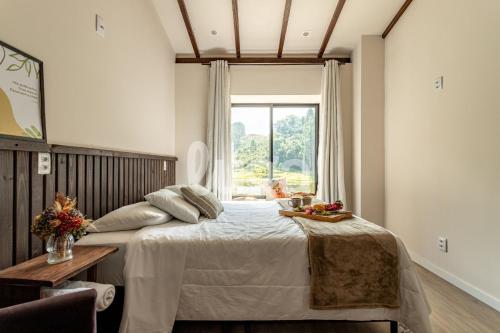 a bedroom with a large bed and a window at Faxinal das Águas Retreat - 5min from downtown in Rancho Queimado