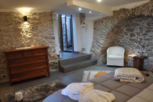 a bedroom with a stone wall with a bed and a dresser at Bed & Breakfast StudioArcodia- in San Marco dʼAlunzio
