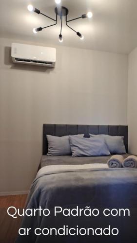 a bedroom with a bed with a air conditioner on the wall at Villa Container in the Wine Route in São Roque