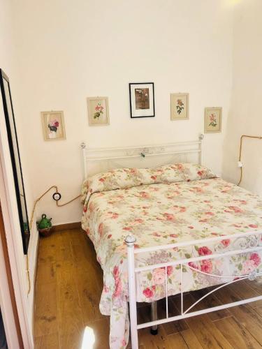 a bedroom with a bed with a floral bedspread at La Mansarda di Terelle in Terelle