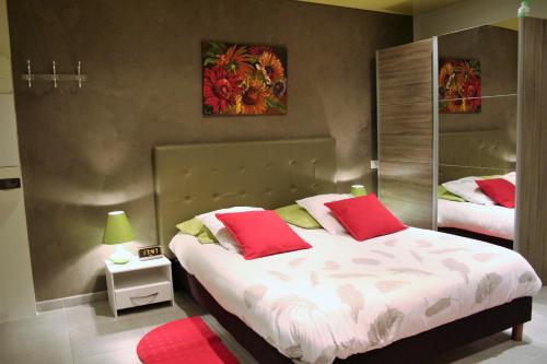 - une chambre avec 2 lits et des oreillers rouges dans l'établissement Les Hellebores, à Caudebec-en-Caux