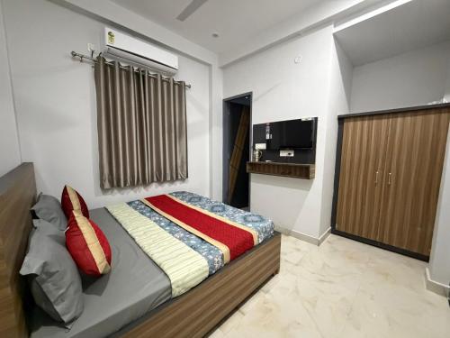 a bedroom with a bed and a television in it at Amrit bela in Haridwār