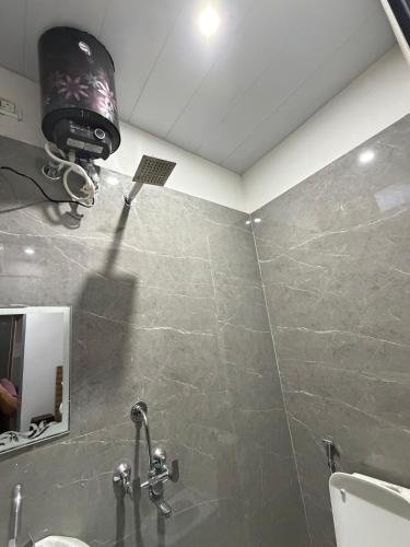 a bathroom with a shower with a light on the wall at Amrit bela in Haridwār