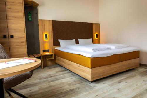 ein Schlafzimmer mit einem Bett, einem Schreibtisch und einem Tisch in der Unterkunft Hotel am Park Bad Driburg in Bad Driburg
