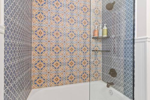 a bathroom with a shower with a tile wall at Bright 3BR | 25 mins to Arrowhead | Groups & Pets in Mission