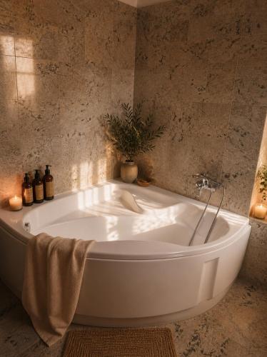 a white tub in a bathroom with a plant at Il Castelletto di Gomo - Relax nella natura con SPA privata outdoor in Godiasco
