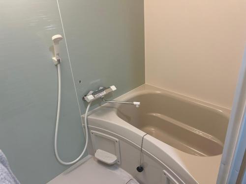 a small bathroom with a toilet and a bath tub at ビジネスホテルinn in Kashima