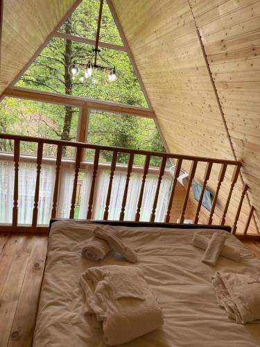a bed in a room with a large window at Makhuntseti Inn in Makhunts'et'i