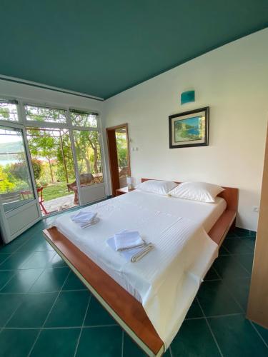 a bedroom with a large bed with white sheets at Apartments Sijerkovic in Herceg-Novi