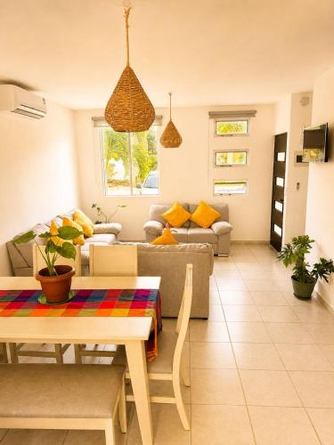 a living room with a table and a couch at Casa Coral in Puerto Morelos