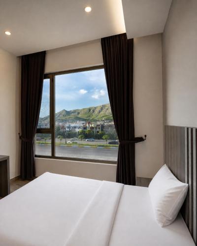 a bedroom with a bed and a large window at Wan Hotel in Duhok