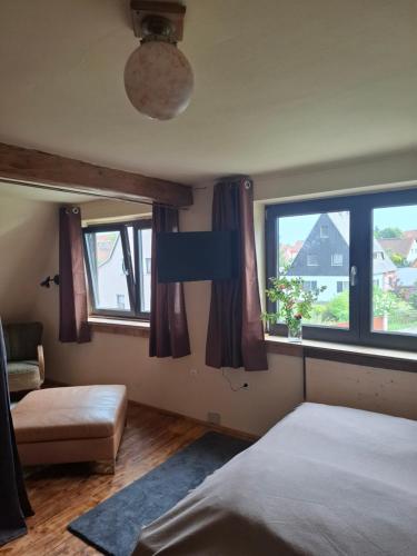 a bedroom with a bed and two windows at Ferienhaus Witta in Radebeul