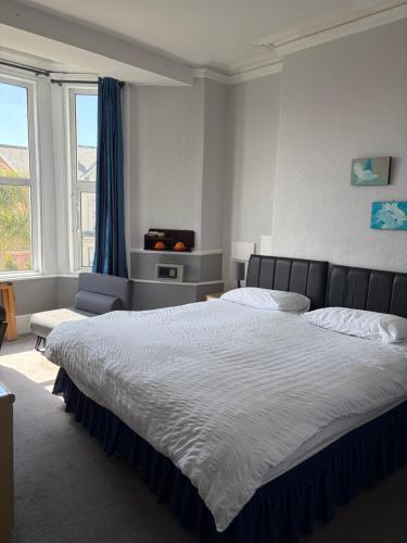 a bedroom with a large bed and a large window at Adelphi Guest House in Douglas