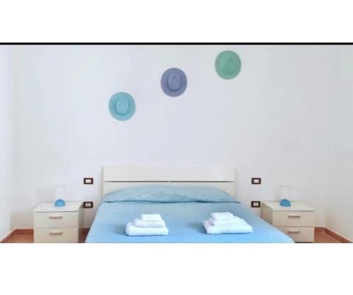 a bedroom with a blue bed with two towels on it at Casa Arborea in Sennori