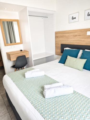 a bedroom with a bed with two towels on it at Green Bay Suites in Protaras