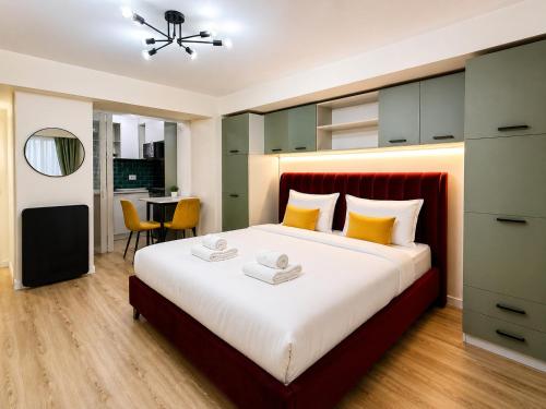 a bedroom with a large bed with yellow pillows at Victoriei Studio Old City in Bucharest