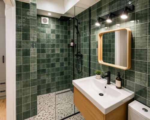 a green tiled bathroom with a sink and a mirror at Victoriei Studio Old City in Bucharest