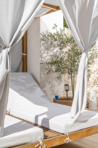 a bed in a room with white curtains at Jakov & Antonia Heritage Estate in Hvar
