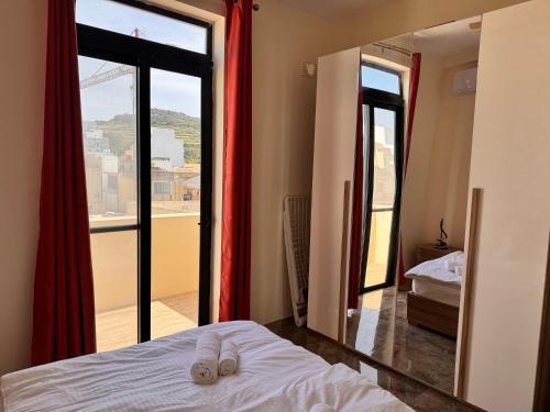a bedroom with a mirror and a bed and a window at Brand new Oceanview Penthouse by MaBeLi in St. Paul's Bay