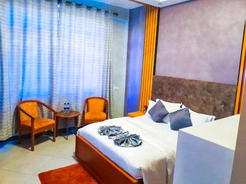 a bedroom with a bed and a table and chairs at RIVANA HOTEL Goba in Dar es Salaam