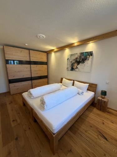 a bedroom with a large bed with white sheets at Ferienwohnung Andreas in Holzkirchen