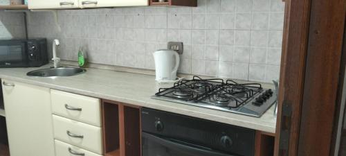 a kitchen counter with a stove and a sink at Adda House in Trezzo sullʼAdda