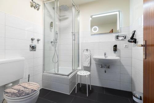 a bathroom with a shower and a toilet and a sink at Hotel an der Hörn in Kiel