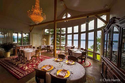 ein Esszimmer mit Tischen und Stühlen und einem Kronleuchter in der Unterkunft Eagle's Nest Resort in Anahim Lake