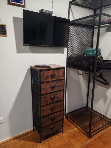 a bedroom with a bunk bed and a dresser and a television at La Casita Verde in Boquete