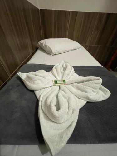 a white towel on a bed in a room at Pousada Imperatriz in Aparecida