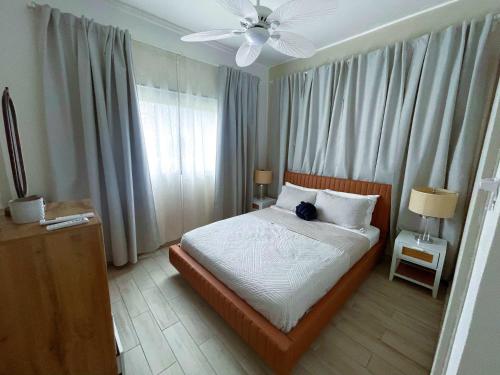 a bedroom with a bed and a ceiling fan at Private Beach Community - White Sands Golf Resort - Modern 2BR Private Pool and Patio in Punta Cana