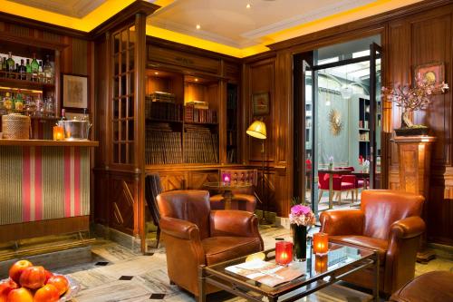 bar z 2 krzesłami i stołem w pokoju w obiekcie Best Western Premier Trocadero La Tour w Paryżu