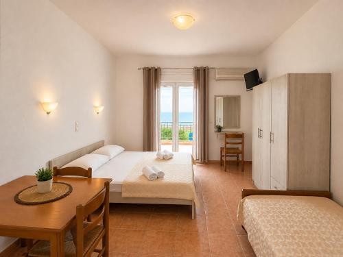 a hotel room with two beds and a table at Τηλεμαχος Apartments in Loutra Edipsou