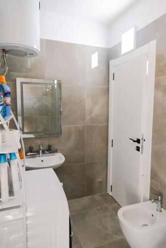 a bathroom with a sink and a toilet and a mirror at Salt & Serenity Apartment in Orikum