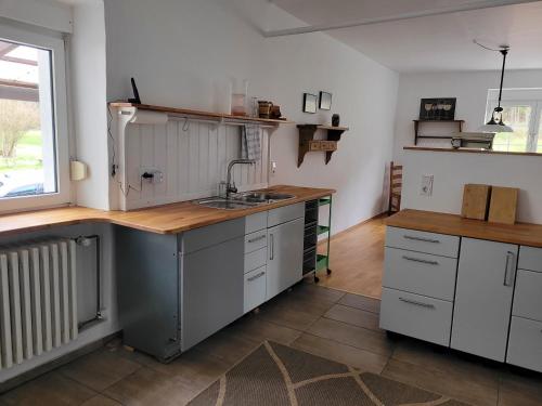 a kitchen with white cabinets and a sink at Lauberhof in Trippstadt