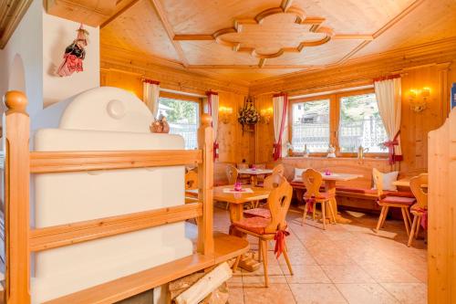 a log cabin with a dining room and dining table at Hotel Garni la Stua in Selva di Cadore