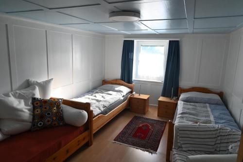 a bedroom with two beds and a couch and a window at Ferienwohnung "Posta Veglia" - Cumbel in Cumbels