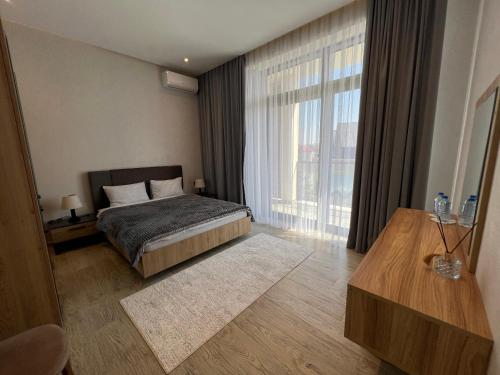 a bedroom with a bed and a large window at Sea Breeze Polo Residence in Baku